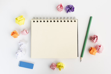 Blank spiral diary surrounded by crumpled paper with pencil and eraser