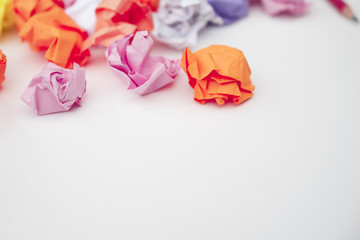 Close-up of colorful crumpled paper on white desk