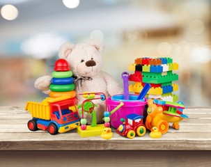 Bear and colorful toys on desk wooden background
