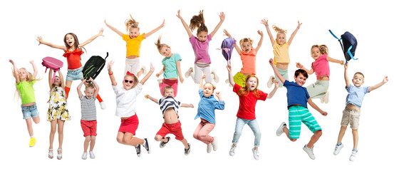 Group of elementary school kids or pupils jumping in colorful casual clothes jumping isolated on white studio background. Creative collage. Back to school, education, childhood concept.