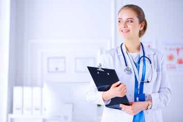 Female doctor in the office with a folder in her hands and a stethoscope. The doctor in the office.