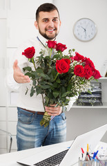 Smiling young male presented flowers woman