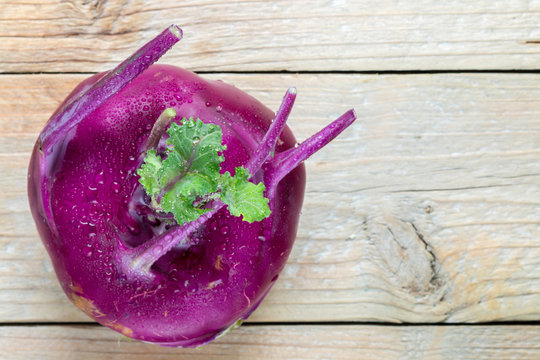 Fresh organic purple kohlrabi cabbage on wooden table. The harvest of vegetables. Selective focus