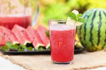 Delicious refreshing summer fruit - watermelon juice and slices on the table