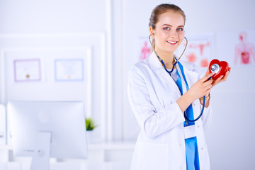 Doctor cardiologist examines the heart with a stethoscope. Young female doctor in a hospital