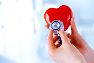 Doctor with a stethoscope examines the heart. Young doctor cardiologist in a hospital