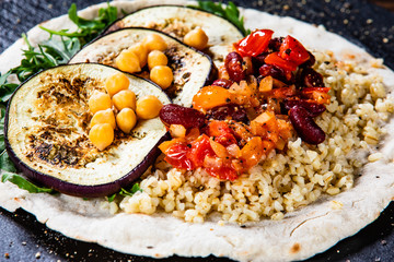 Groats with sauce and vegetables on tortilla