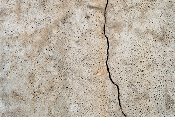 Crack and porosity on the surface of the concrete construction. Texture of defective building structure.