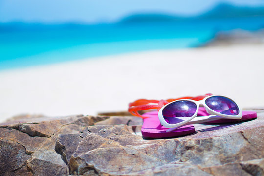 sunglasses on flip flop on the beach, concepts