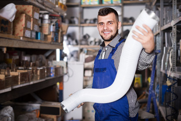 Man worker choosing aluminum ventilation pipes