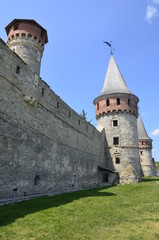 Obraz premium The wall and towers of the magic fortress in Kamyanets-Podilsky in Ukraine against the background of a blue-haired sky