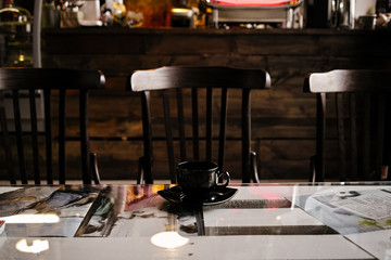  black cup of coffee on a table in a cafe interior on a dark background