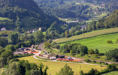 Naklejka premium Work in Progress along the Railroad among Green Hills