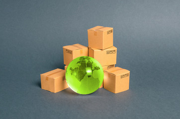 Green glass planet globe and a pile of cardboard boxes. Business and industry, transport...