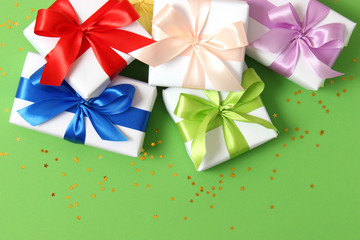 gifts and confetti on a colored background top view. Holiday giving gifts