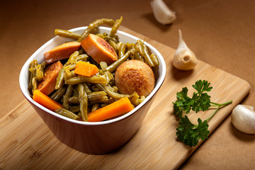 Stew made from green peas with pork sausages