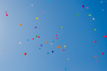 Balloons flying away into the blue sky