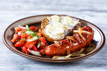 Grilled sausage, toast and vegetable salad