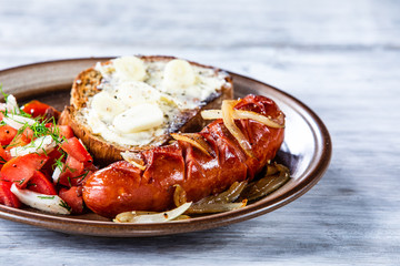 Grilled sausage, toast and vegetable salad