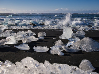 Gletschereis an der Küste am schwarzen Sandstrand