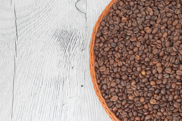 coffee grains lie in a wicker plate on a beautiful background