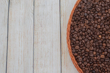 coffee grains lie in a wicker plate on a beautiful background