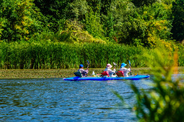 Senior man and two women kayaking on Dnieper river