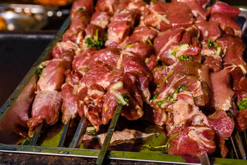 Skewers with raw meat over the charcoals. Cooking shashlik