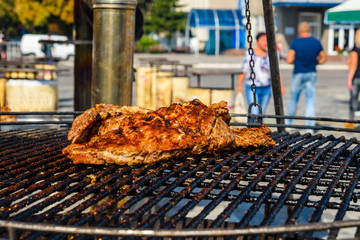 Piece of the meat cooking on metal grate grill