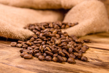 Sackcloth and scattered coffee beans on wooden table