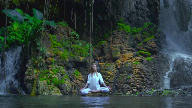 Serenity and yoga practicing, woman meditate at waterfall with natural pool