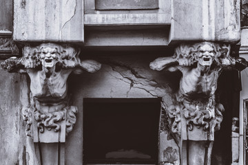 bust of concrete of a terrible woman on the facade of an old house