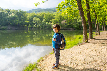 A boy with a backpack on the lake.