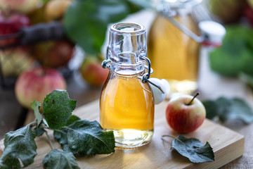 Apple vinegar. Bottle of apple organic vinegar or cider on wooden background. Healthy organic food.
