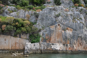 Kekova Island Sunken Ruins in Turkey. Rocks with ruined houses and trees and Mediterranean sea.