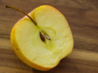 Apple cut in half with stem, core and seeds.