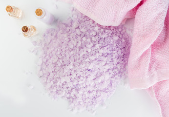 Lavender spa setting: salt, essential oil natural spa products and decor for bath on light background