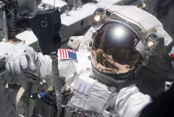 Fototapete Nasa Der Astronaut in einem Raumanzug im Weltraum ist mit der Reparatur der Raumstation beschäftigt. Elemente dieses Bildes wurden von der NASA bereitgestellt