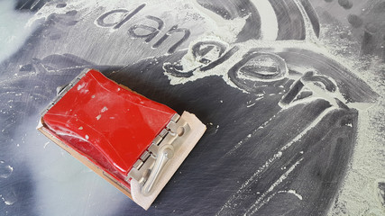 timber for grinding, plastic, placed on the hood of the car and the top finger is written Dangerous