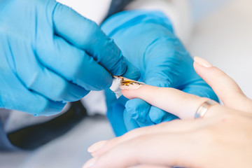 Woman manicure master makes gel coating varnish in the salon. Concept of beauty professional nail care