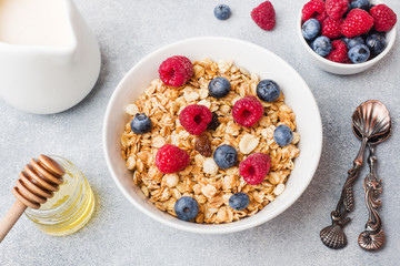Healthy breakfast. Fresh granola, muesli with yogurt and berries on grey background. Copy space