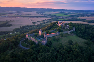 Helfstyn castle (German: Helfenstein, Helfstein), aerial view of a gothic castle in vibrant colors of setting sun, perched on high knoll above the Moravian Gate, Central Moravia, Czech Republic.