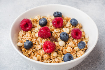 Healthy breakfast. Fresh granola, muesli with yogurt and berries on grey background. Copy space