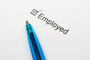 employed-checkmark on white paper with pen.