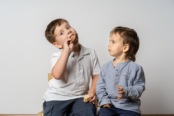 Funny little boy picks up another boy*s food. Dissatisfaction. Concept- food conflict.