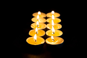 Candles burning in the dark. Holiday, Romance or Religion concept. Candles on a wooden background