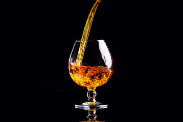 glass with cognac on a black background