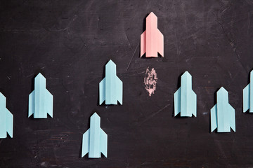 Think different and individuality vision or idea concept.Red paper rocket flies ahead of the group
