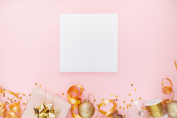 Notebook  with golden bow on pink coral background with stars and sparkles. Festive  and wish list . New year resolutionconcept copyspace top horizontal view. 