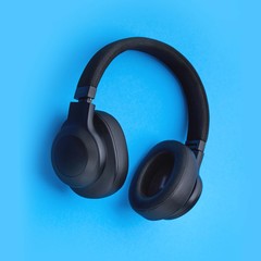 Black headphones on a colored background. Music concept with copyspace. Headphones isolated